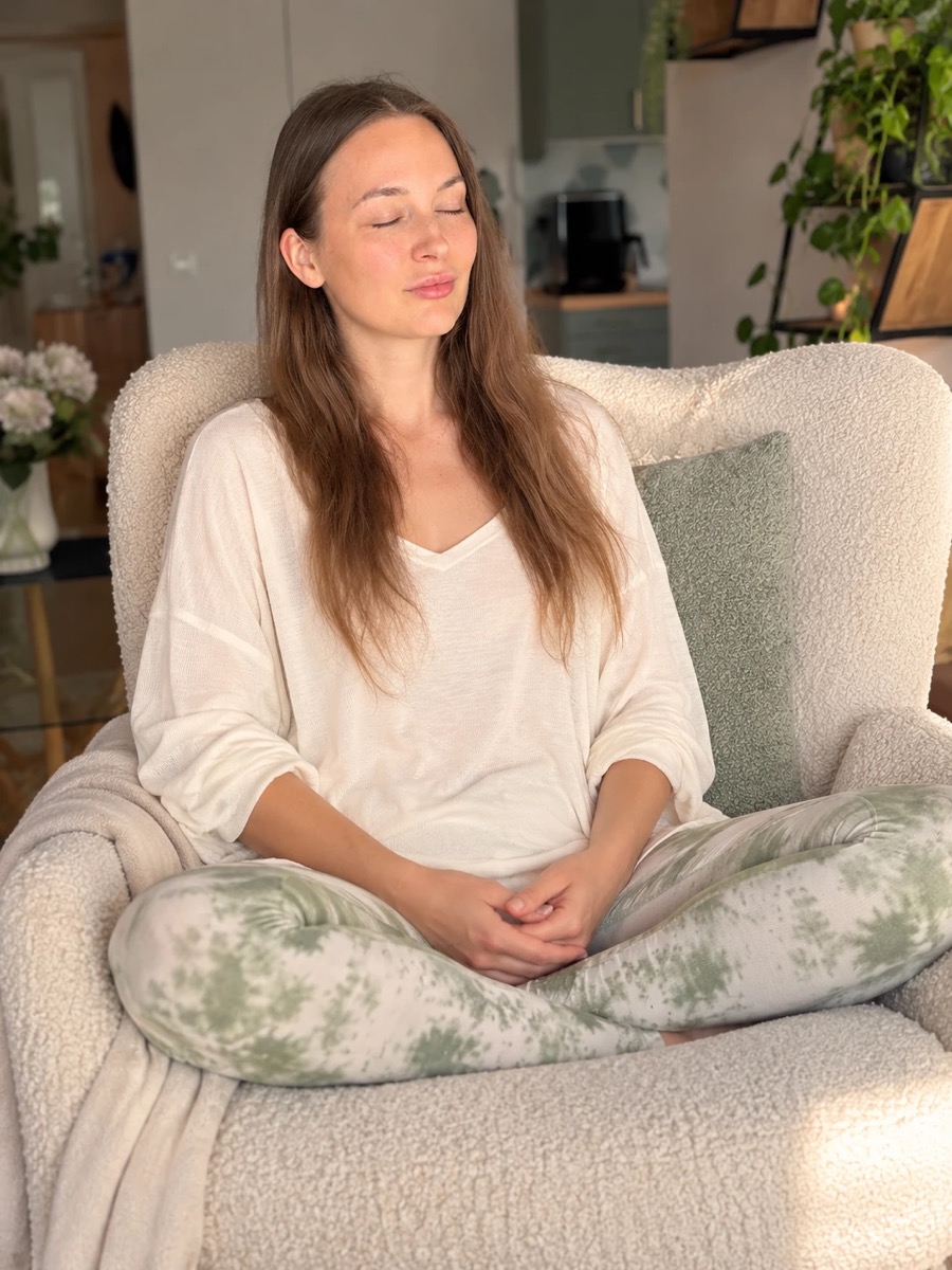 Király Anita csukott szemmel meditál egy fotelben, keresztbe tett lábbal