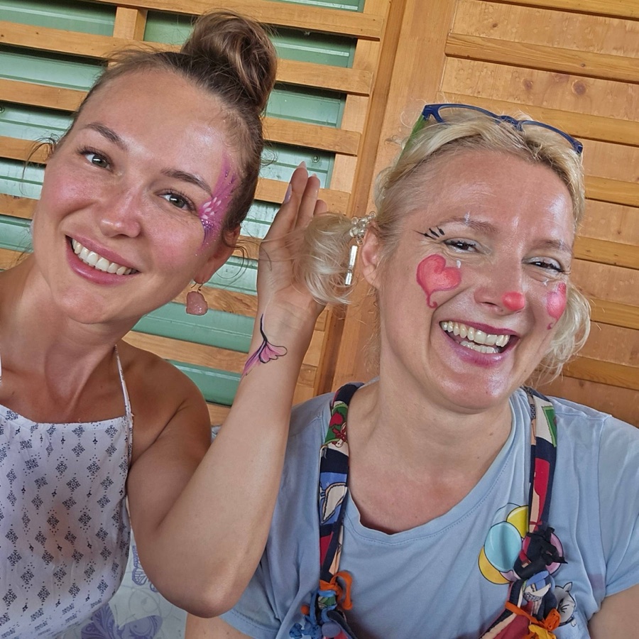 Király Anita pillangós arcfestéssel, mellette a bohócnak öltözött arcfestő