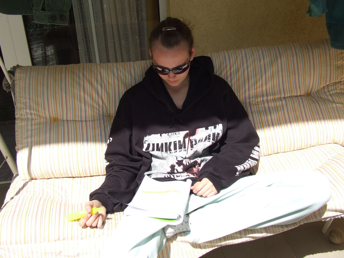 Tizenéves Király Anita napszemüvegben, Linkin Park-pulóverben, jegyzetet kiemelve